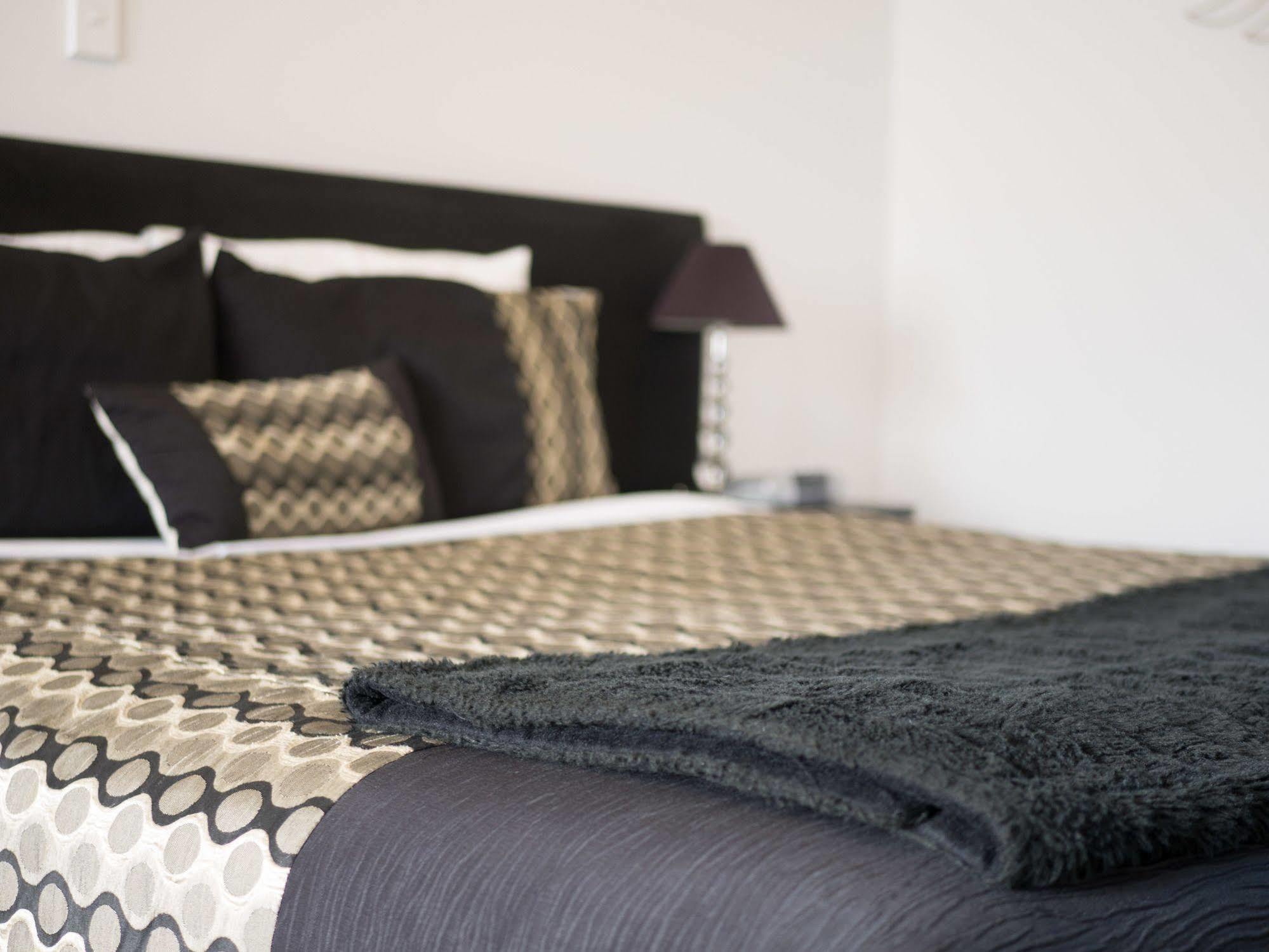 Bellano Motel Suites ไครสต์เชิร์ช ภายนอก รูปภาพ A bed with a throw